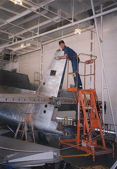 TBM_14.jpg - Caught cleaning the plane. Elevators on top of pallets on the deck. All fabric was replaced.